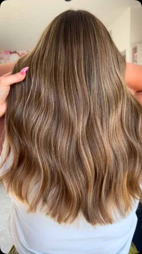 Lang golvend haar van achteren gezien, bruin met goudblonde dieptewerking.