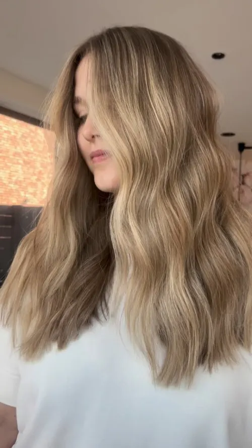 Lang blond golvend haar waarin de overgang tussen de tinten volledig vervaagd is.