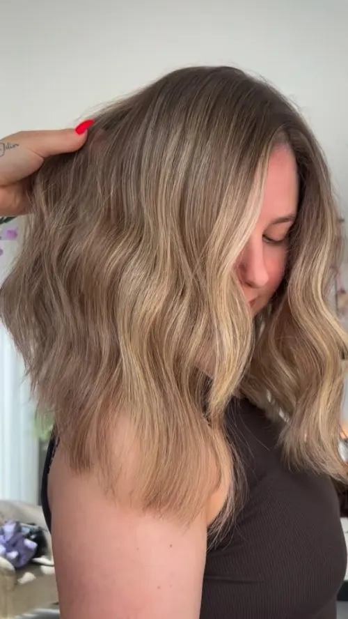 Lang golvend haar met een blonde balayage die geleidelijk lichter wordt naar de punten.